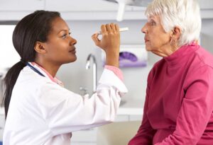 Elderly woman getting eyes examined by female doctor